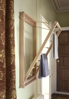 a wooden rack with clothes hanging from it's sides in front of a door