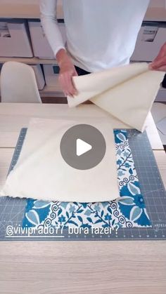 a person is cutting fabric on top of a table