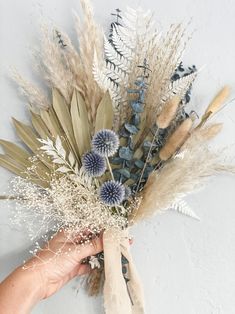 a person is holding some dried flowers in their hand