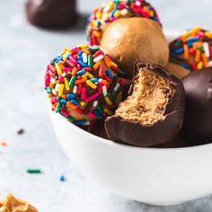 a bowl filled with chocolate covered donuts and sprinkles