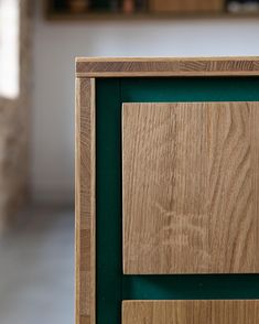 a close up of a wooden cabinet with green trim