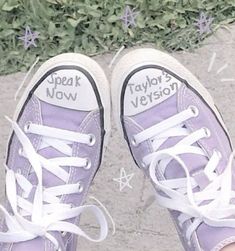 someone is wearing purple converse shoes with white laces and writing on the soles