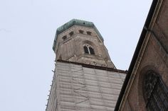 a tall building with a clock on it's side and a steeple in the background