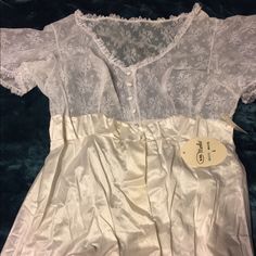 This Will Need To Be Steam Pressed But Ironing Is Not My Forte So I Will Leave It To The Lucky Purchaser. This Is An Absolutely Stunning Vintage Peignoir Still With Tags In A Size Large! It Is Very Full And I See No Damage. It Just Needs To Be Ironed. The Top Lace Is Still Crisp! I Just Can’t Resist Vintage When I See It But It Is Time For Me To Let Some Of It Go. Although It Says White On The Tag, I Would Call It Ivory. Vintage V-neck Wedding Sleepwear, Vintage Lace V-neck Nightgown, Sheer Nightgown For Wedding, Fitted Lace Trim Sleepwear For Wedding, Vintage White Night Dress, Fitted Wedding Sleepwear With Lace Trim, Fitted White Sleepwear With Lace Bodice, Fitted White Chemise For Wedding, White Fitted Chemise For Wedding