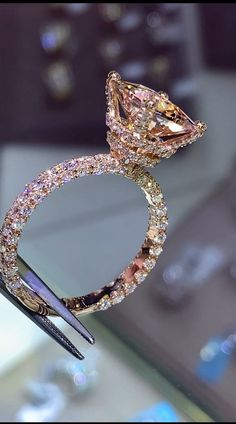 a fancy diamond ring being held by a pair of scissors