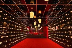 a red carpeted room with lights and lanterns hanging from the ceiling, along with other decorations