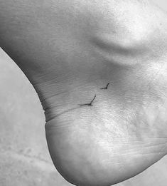 a person's foot with a small tattoo on it