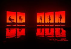 the silhouettes of three people are reflected in a red room with four square windows