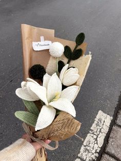 a person holding a bouquet of flowers on the street