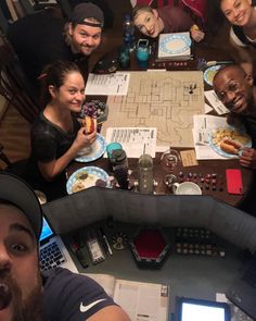 a group of people sitting around a table with plates and food in front of them