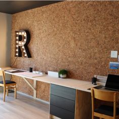 a room with a desk, chair and light up letters on the wall