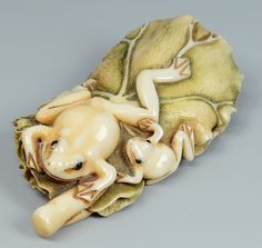 a ceramic figurine of a frog laying on its back