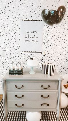 a white dresser sitting in front of a wall with black and white polka dots on it