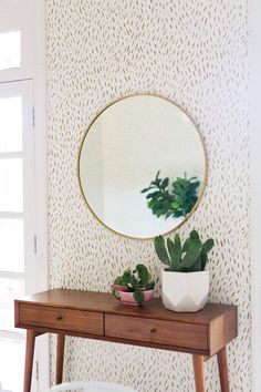 a wooden table topped with a mirror next to a potted plant on top of it