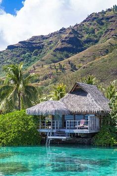 the water is crystal blue and clear with some huts on it's roof overhangs