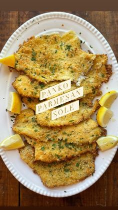 panko parmesan sole on a white plate with lemon wedges and herbs