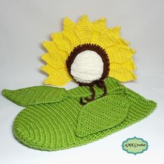 a crocheted sunflower sitting on top of a green leaf