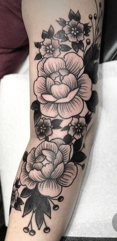 a black and white flower tattoo on the arm