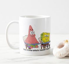 a donut sitting next to a coffee mug with an image of spongebob on it