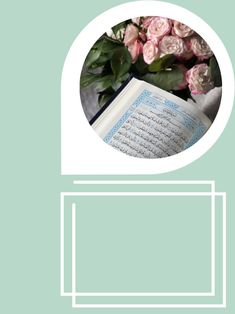 an open book sitting on top of a table next to pink flowers and greenery