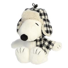 a white stuffed dog with a black and white checkered hat on it's head