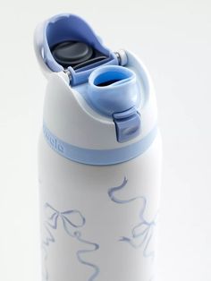 a white and blue water bottle on a white surface with the lid up, sitting in front of a white background