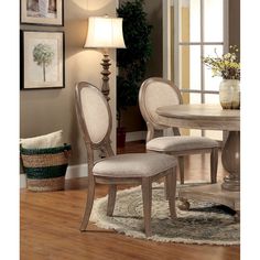 a dining room table with two chairs and a rug