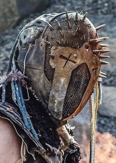 a close up of a person wearing a helmet with spikes on it