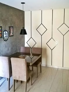 a dining room table with four chairs in front of it and three pictures on the wall