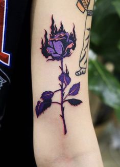 a purple rose tattoo on the left arm