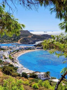 the beach is surrounded by trees and blue water