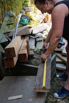 a woman measuring the length of a piece of wood