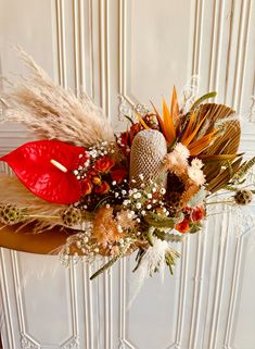 an arrangement of flowers and feathers on a table