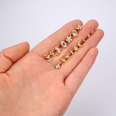 a person's hand holding five different types of rings