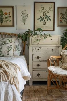 a white bed sitting next to a wooden dresser in a room with paintings on the wall