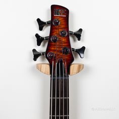 an electric bass guitar with four strings hanging from it's neck and two heads facing the same direction