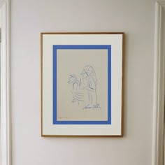 a blue and white drawing hangs on the wall