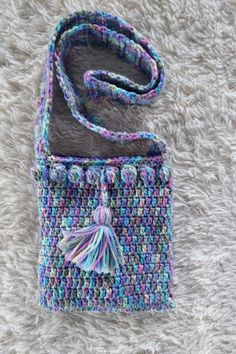 a multicolored crocheted bag with a tassel on the front and side