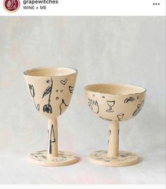 two wine goblets sitting next to each other on top of a white table