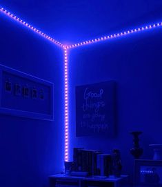 the room is lit up with blue lights and books on the table in front of it