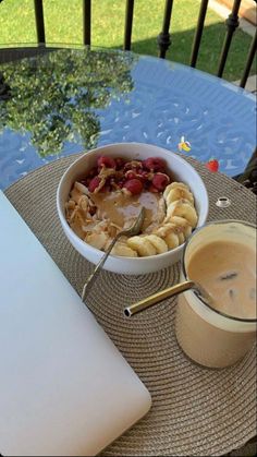 a bowl of food on a table next to a cup of coffee