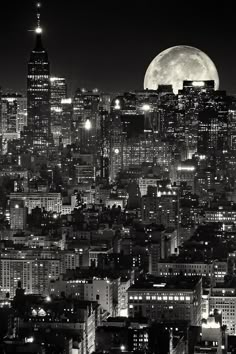 black and white photograph of the city skyline at night with full moon in the background