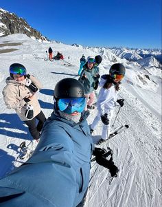 a group of people riding skis on top of a snow covered slope