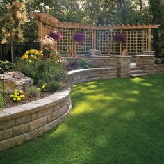 a garden with green grass and flowers in the center, surrounded by stone walls and trelliss