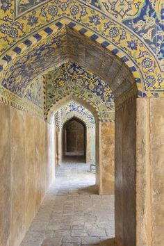 an archway in the middle of a building with blue and yellow tiles on it