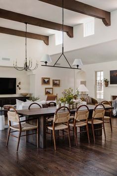 a dining room table with chairs and a television in the background