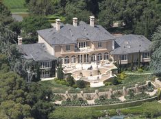 an aerial view of a large mansion in the woods