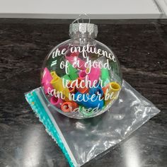 a glass ornament with writing on it sitting on top of a piece of plastic