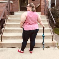 a woman standing on the steps holding an umbrella