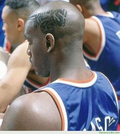 a group of men sitting next to each other on top of a basketball court with writing on their backs